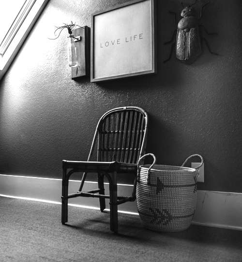 Aesthetic corner setup with bamboo chair, woven basket, and wall decor – love life quote, slow living, rustic vibe